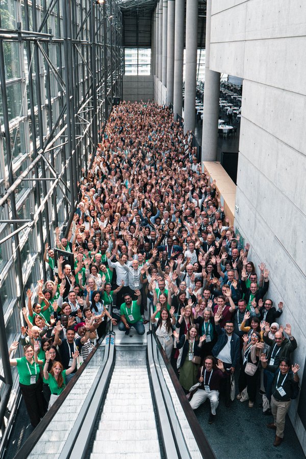 Many conference attendees are standing in the entrance hall.
