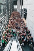 Many conference attendees are standing in the entrance hall.
